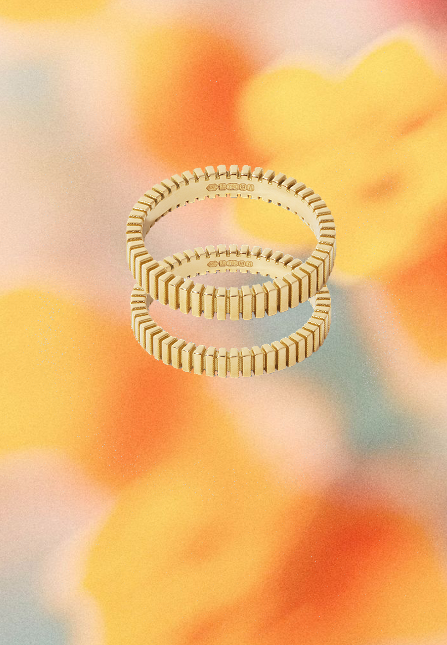 Two gold rings stacked on a colorful abstract background